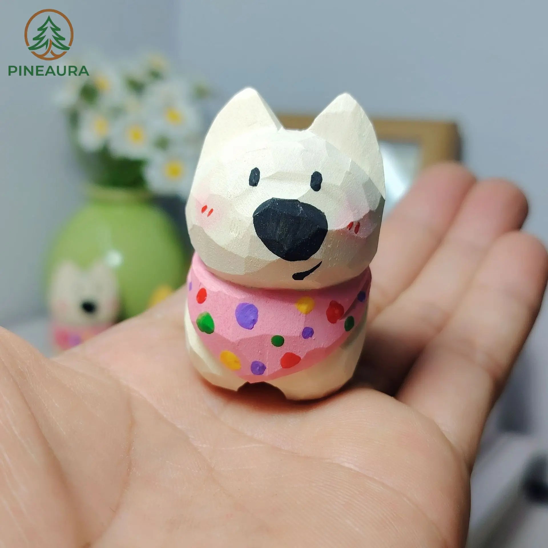 Adorable low-poly white West Highland Terrier figurine with pink polka dot bandana, held in hand by PINEAURA